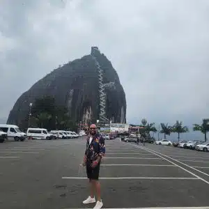 Tourist standing in front of La Piedra del Peñol rock in Guatapé Colombia