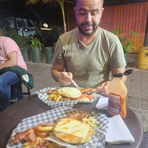 Colombian street food in Medellin at night with chuzos hot dogs fries and cheese outdoor terrace